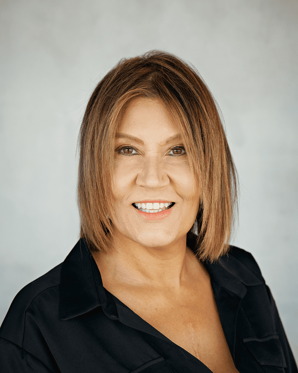 Headshot of Kellie Hunt Blue wearing a black collared shirt against a plain light gray background.