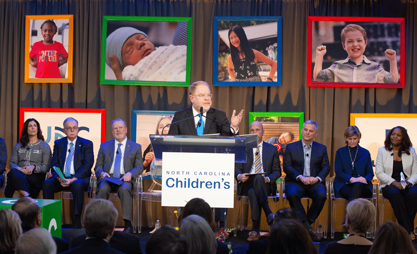 President Hans speaking at a podium about the new NC Children's Hospital