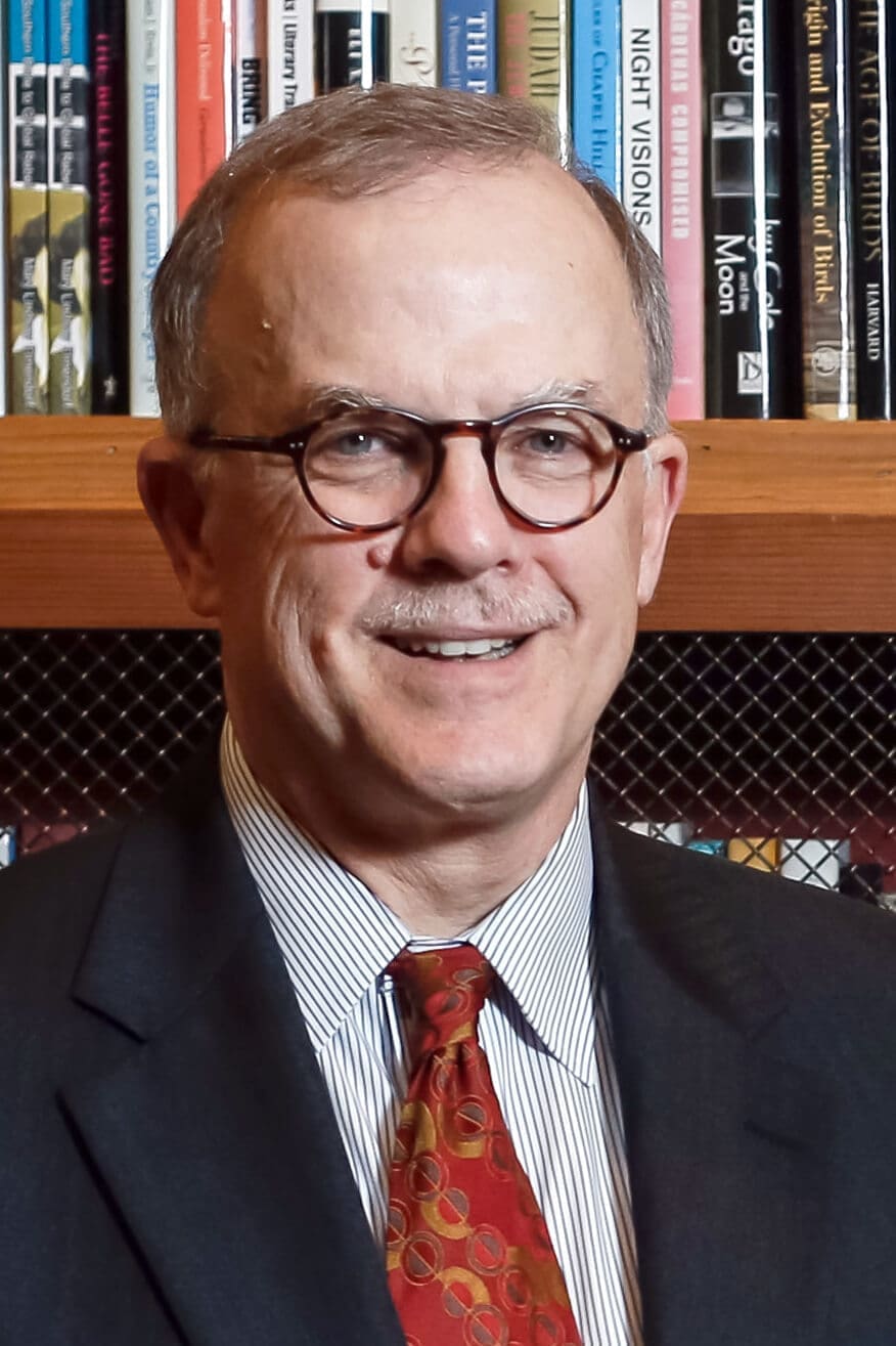 Mike Smith, smiling with a wall of books behind him