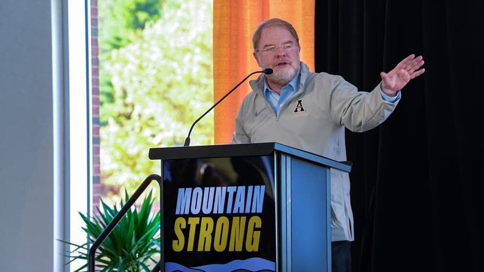 President Hans speaking at an App State podium labeled "Mountain Strong" 